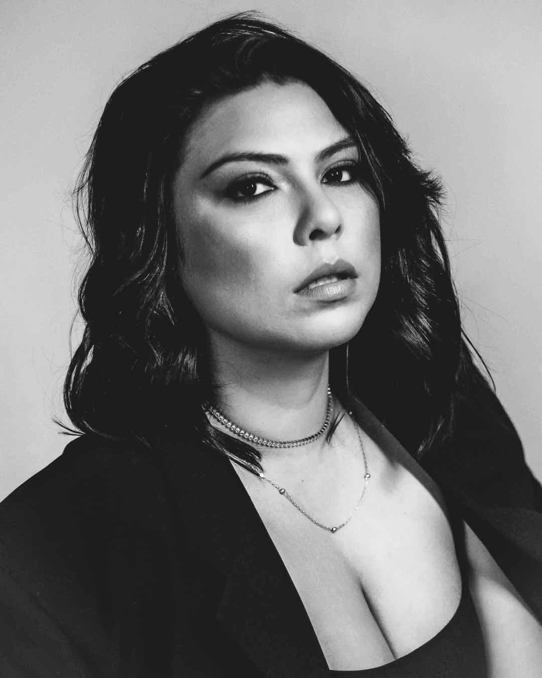 Mulher de cabelos cacheados posando para ensaio em estúdio fotográfico