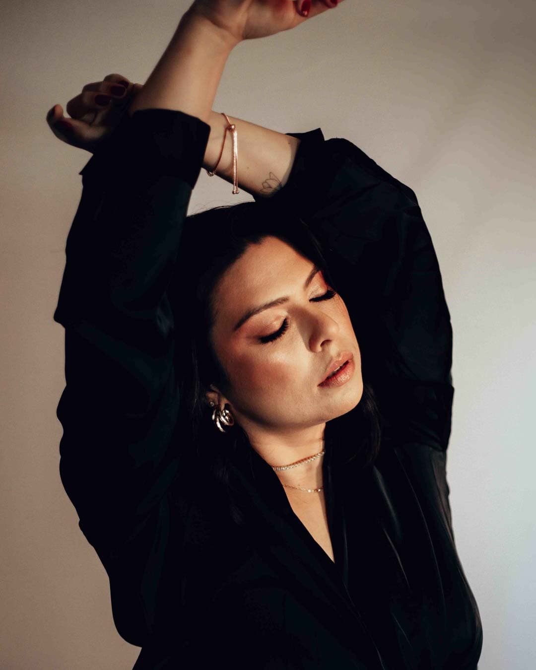 Mulher posando em ensaio fotográfico feminino em estúdio de Joinville, usando salto alto e jaqueta de couro